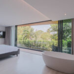 Bedroom with smart TV overlooking the garden view, including outdoor balcony seating area