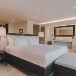 Balinese design bedroom with king size bed, bed bench and ensuite bathroom with bathtub and his and hers sinks