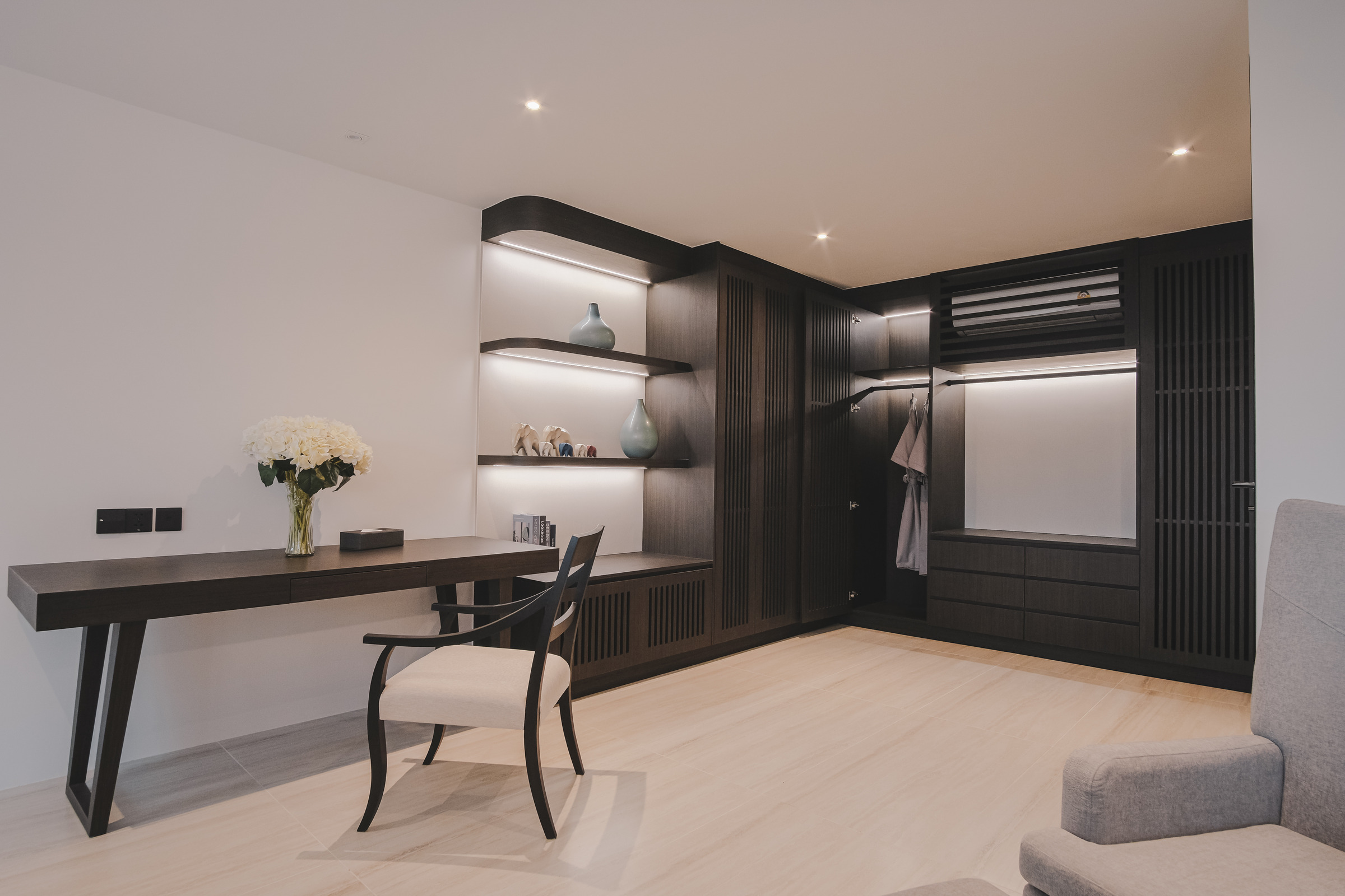 Bedroom workspace area with wing chair, bookshelf, and closet