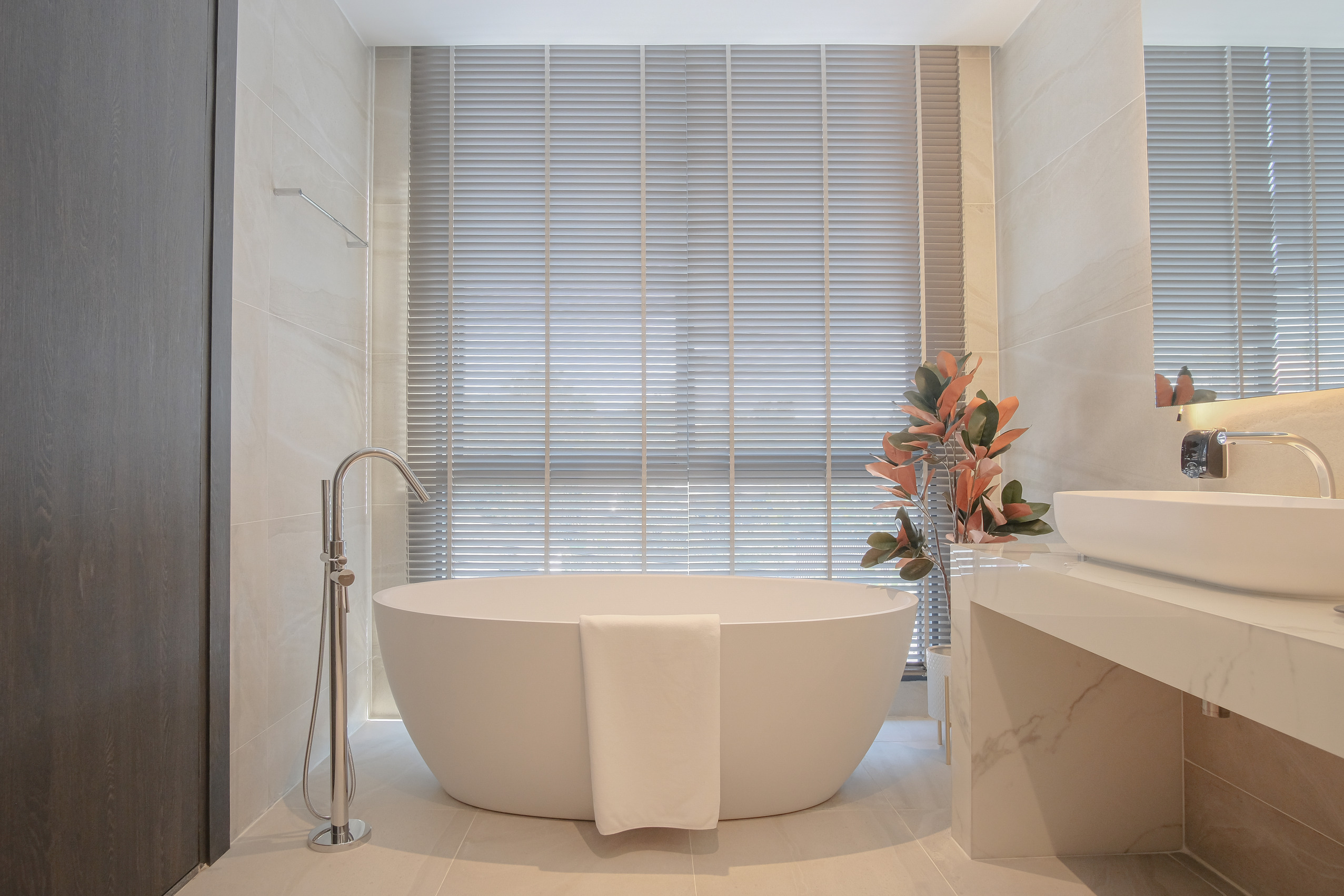 Bathtub next to window for outdoor view and his and hers sinks