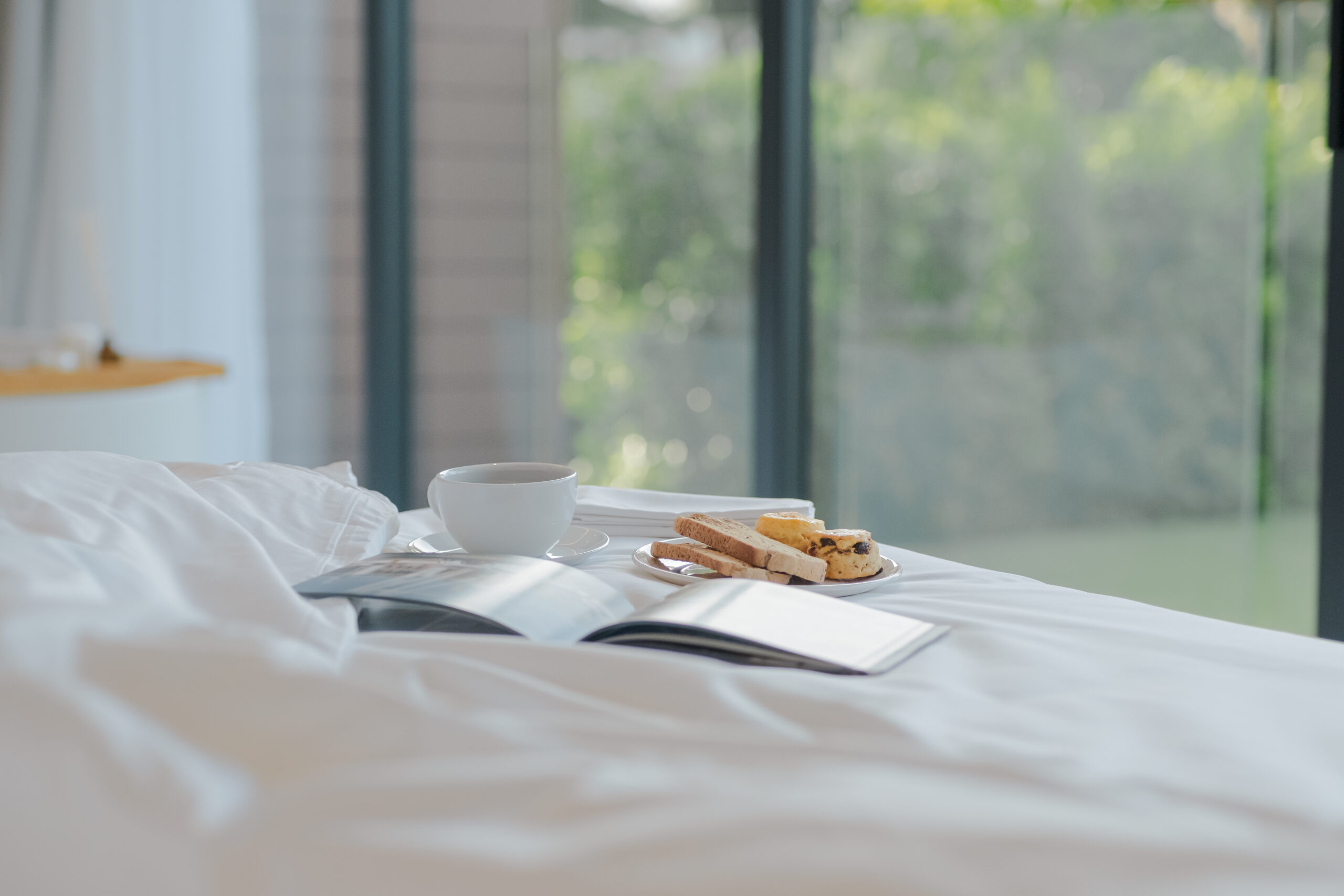 Breakfast in bed with books, coffee, and bakery